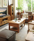 Cozy living room with wooden furniture, including chairs, tables, and a TV stand, adorned with plants and decor items near a large window.