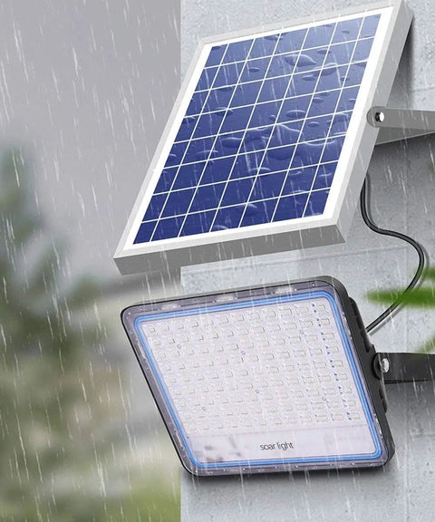 Hella Bright 200 Watt Solar Flood Light With Integrated Remote And Badass IP67 Waterproof Shell mounted with solar panel in rain.
