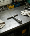 Heavy Duty Car Body Dent Puller Set For Sheet Metal Panels And Doors With T Bar tool on a workbench surrounded by supplies.