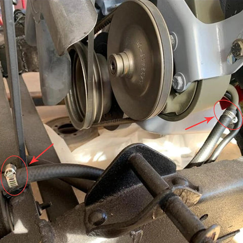Adjustable stainless steel hose clamps securing fuel lines in automotive repair.