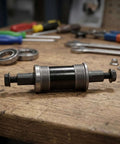 Solid Alloy Bike Bottom Bracket 73x124mm For E-Bikes With Iso Square Taper Fits Your Ride And Handles Harsh Snow Or Beach Sand Like A Boss Without Any Wobbly Issues. on workbench
