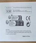 Warning label for Dead Simple Automatic Twist Tie Machine With Five Shiny Gold Metallic Wire Rolls, instructions in multiple languages.
