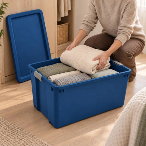 Massive 45 Gallon Rolling Storage Tote With Easy Glide Wheels To Tackle Heavy Hauling Tasks Without Breaking A Sweat Plus Stackable Design For Sweet Organization Solutions In Blue filled with neatly rolled blankets.