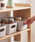 Ten Pack Gray White Plastic Storage Bins With Reinforced Handles For Home Organization And Closet Pantry Use Stackable Small Containers coordinating with jars on wooden shelf.