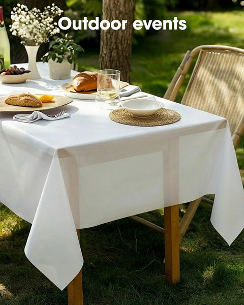 No Drama Cleanup Disposable Plastic Tablecloths Rectangle Table Cover 54X108 Inches White on an outdoor dining table with food.