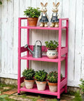 Rolling 3 Tier Metal Storage Organizer With Soft Pink Finish And Adjustable Foot Pads For Squishy Spaces Featuring Pop Off Guard Panels To Knock Kitchen Laundry And Garage Jumble Down Easy For Stress Free Home Upkeep Anywhere You Park It with plants and decor.
