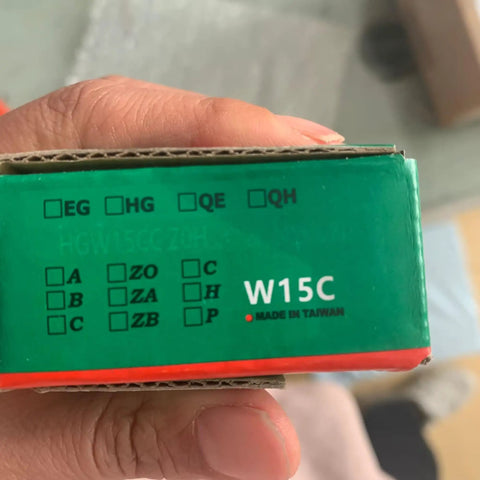 Close-up of HGW15 linear guide rail packaging with identifiable product codes, held in hand.