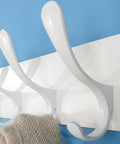 Close-up of white hooks on Wooden Wall Coat Rack With Six Hooks White Finish Modern Space Saving Wall Hanger for coats and clothes