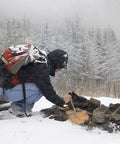 Person using Natural Jute Fire Starters 6-Piece Set For Quick Ignition in snowy forest to ignite campfire.