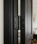 Close-up view of 24 Pack Black 3 Inch Soft Close Door Hinges Heavy Duty on a black door frame