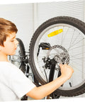 Child servicing a mountain bike wheel with a focus on the Complete Mechanical Disc Brake Set For Mountain Bikes Featuring Front And Rear 160 Mm Silver Aluminum Rotors Dual Adjustment Calipers Solid Pads And Ready To Roll Cable Kit.