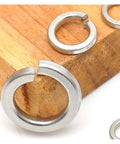 Rock Solid Stainless Steel Split Lock Washers Heavy Duty Elastic Spring Gaskets on wood background for M2 to M30 fit.
