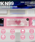 Top Shelf Wireless Mechanical Keyboard With Smart Screen And Rotary Knob, Gasket Mounted Hot Swap Tactile Switches Pre Lubed For Silky Typing, Triple Mode Bluetooth And Usb Setup, Compact 96 Percent Layout That Goes Hard For Gaming on a pink desk with a smartphone and mouse.
