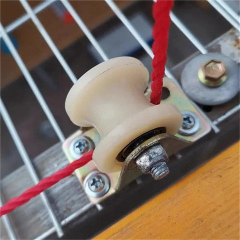 Close-up of a Single Nylon Groove Roller Wheel For Sliding Barn Doors Linear Track Pulley with red rope attachment.