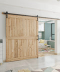All In One Heavy Duty Sliding Barn Door Hardware Kit Features 11 Foot Track With Whisper Quiet Nylon Rollers For Rock Solid Reliability Smooth Silent Operation Dead Simple Install Durable Alloy Frame No Door Included Matte Black Finish, showcasing a wooden barn door.