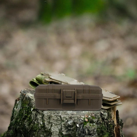 Tough As Nails Heavy Duty Plastic Toolbox With Interlocking Stackable Design And Thick Three Layer Foam Cushioning resting on a log.