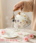 Stovetop Whistling Tea Kettle Two Point Seven Quart Floral Pattern Stainless Steel Tea Pot With Wood Pattern Handle Perfect For Boiling Water Coffee Or Milk Durable All Stovetop Kitchen Must Have For Real Essential pouring water into cup