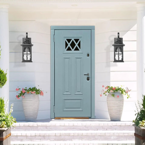 Rock Solid Aluminum Outdoor Wall Light Featuring Slick Water Ripple Glass Exterior Fixture And Helluva Tough Weatherproof Porch Sconce Plus Knockout Doorway Accent For Backyard Or Garage Entry beside blue door with decorative flower pots.