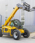 Heavy Duty Telescopic Handler Forklift Featuring Nineteen Meter Intelligent Boom Extension And Integrated Load Moment Indicator Crew Approved Workhorse For Tough Job Sites with raised forks against a building.