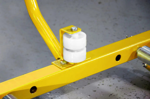 Close-up of Heavy Duty Rock Solid Tire Wheel Roller Dolly featuring ergonomic grip, showing white rollers on yellow frame.