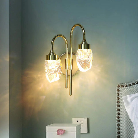Modern Double Head LED Wall Sconce Rock Solid Hardware Body and Prismatic Crystal Details Knockout Vibe Enhancement in Bedroom or Corridor Luxury Illumination, gold finish, clear crystal shade, mounted on wall.