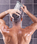 Man using Dual Shower Head System With Rainfall Top Spray And Handheld 70 Inch Flexible Hose Smooth 3 Way Diverter Easy Install Chrome Finish 2 In 1 Shower Head Combo in bathroom.