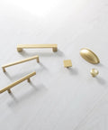 Assorted gold cabinet handles and knobs on white surface