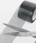 Heavy Duty Window Screen Repair Tape And Mesh Patch Kit 2 Inches By 16 Feet Long Black adhesive strip being cut with scissors.