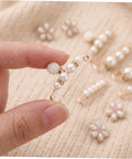 Close-up of Eight Piece Pearl Waist Tightener Pin Set Elegant Alloy Dress Cincher Clips held by hand with pearl details.