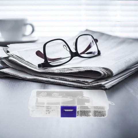 Ultimate Eyeglass Repair Kit Featuring Replaceable Nose Pads And Micro Screwdriver With Assorted Glasses Screws Compact Tool on a table next to glasses and newspaper.