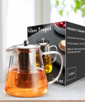 Stovetop Safe Glass Teapot 550ml With Removable Stainless Steel Infuser, displayed with packaging in a kitchen setting.