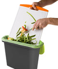 Food scraps being emptied into 9 Liter Portable Bin, part of All-In-One Backyard Compost Kit With 48 Gallon Tumbler, 12 Gallon Wheeled Cart.