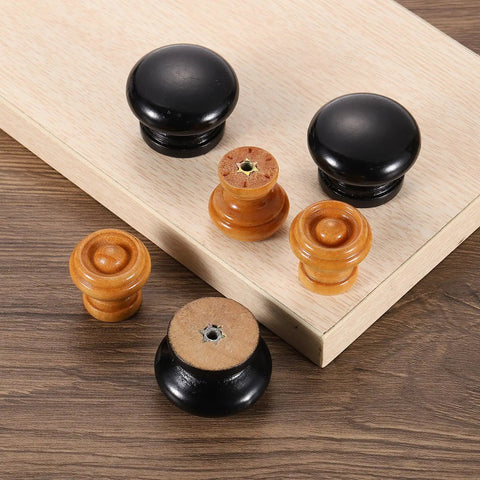 Upgrade Your Kitchen Game With These Swell Red Wooden Cabinet Knobs And Round Drawer Pulls Perfect For Dresser Furniture Makeovers And Top Notch Hardware Upgrades That Look Rad In Any Room - Black and natural wood cabinet knobs on light wood background.