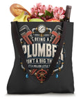 Rad Knucklebuster Plumber Shirt for Pipefitters and Plumbers Being a Plumber Is Not a Big Thing Its a Million Little Things Funny Trade Grind Dad Tee Gift for Handymen Valve Experts with Tote Bag filled with fruits and flowers.