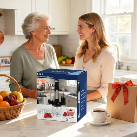 Two women talking in a kitchen with a boxed Powerful 1200W Immersion Hand Blender With 5 In 1 Attachments on the counter.