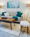 Modern living room with stylish decor, featuring a sofa, wooden coffee table, and ambient lighting from floor lamps. Cozy and contemporary.