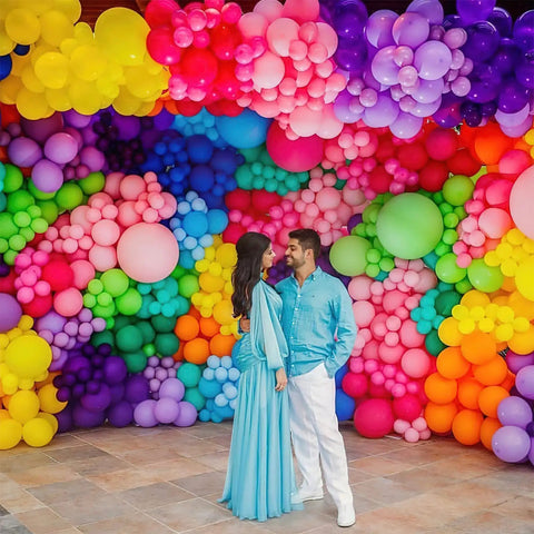 Awesome Assorted Rainbow 5 Inch Latex Balloons 100 Pack For Birthday Bash And Wedding Decor displayed as colorful backdrop at a celebration.