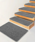Grey stair tread carpet runner set with adhesive backing and nonskid grip, covering indoor wooden stairs, size 9.5 by 30 by 1.2 inches.