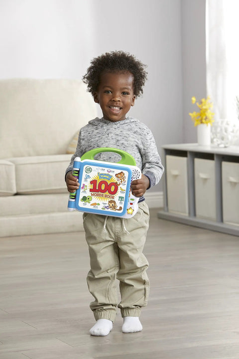 Happy toddler holding the Totally Awesome Interactive Kids Learning Book Featuring Turtle Tiger And Monkey Pals With Touch To Speak Tech.