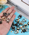 Twenty Pack Slick D Ring Screw Studs With Ball Head Buttons For Leather Crafting And Shoe Repairs Hella Secure Metal Rivet Fasteners in various colors held in hand.