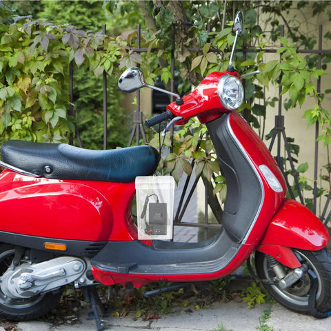 Durable Outdoor Waterproof Electrical Outlet Cover For Universal Charging Stations and Cord Storage Box on red scooter in garden.