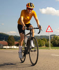 Cyclist on road bike with scenic countryside background