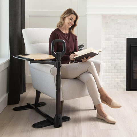 Woman using Adjustable Bamboo Tray Table With Ergonomic Safety Handle And Stand For Couch, reading book by fireplace, in living room