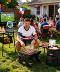 Man grilling next to Camping Fan With LED Lantern And 30000mAh Battery at a backyard gathering during a sports game.