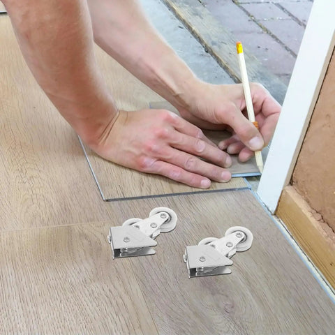 Four Piece Heavy Duty Aluminum Pulley Rollers For Smooth Sliding Doors And Windows Straight Up Quick Swap Garage Track Replacement Hardware laid beside a person marking a floor.