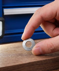 M6 Conical Knurled Spring Lock Washers 304 Stainless Steel 40 Pack held by hand over a wooden surface.