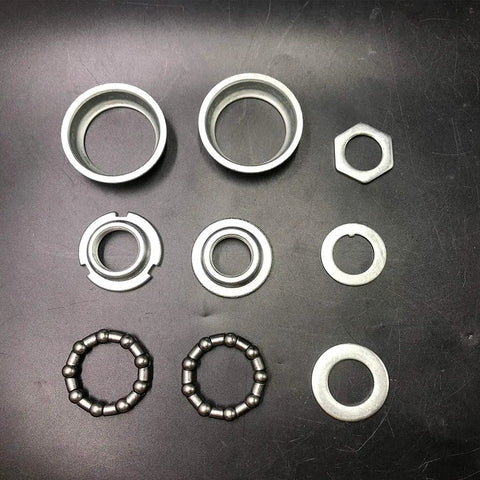 Components of 2 Inch Cup Bottom Bracket Conversion Kit For Bikes Converts One Piece Crank To Three Piece on black background