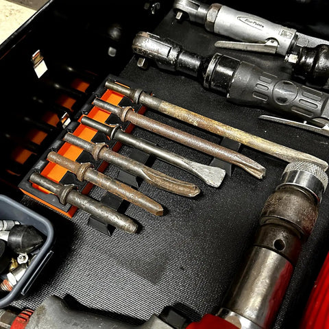 Drawer with various air hammer bits and tools, showing MagAttach Magnetic Air Hammer Bit Tray With Six Slots That Holds Six Chisel Bits And Accessories, Magnetic Base Keeps Your Gear From Rolling, Durable Purple And Black Tool Organizer For Air Hammers.