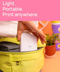 Person placing Ivy 2 Mini Photo Printer For IPhone And Android Zero Ink ZINK Tech Print Sticky Back Photos Directly From Your Smartphone On The Go No Ink Needed Quick Colorful Prints In Pure White Finish into yellow bag