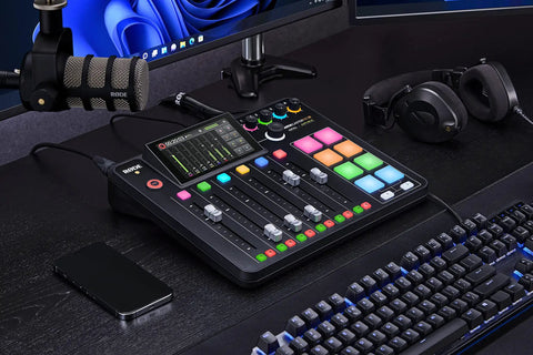 Rodecaster Pro II Integrated Audio Production Console with colorful buttons, connected to mics and headphones on a desk.